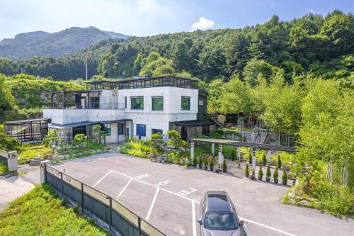 eine Luftansicht eines Hauses mit Parkplatz in der Unterkunft Gapyeong FS Pool Villa in Oebang-ni