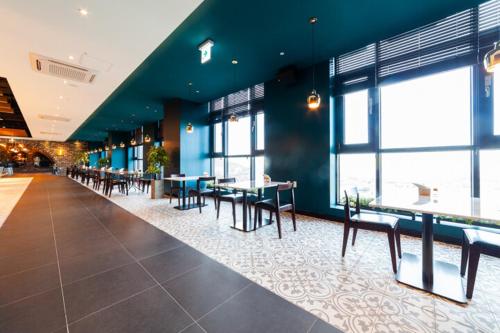 a dining area with tables and chairs in a building at Grand Hillstone Hotel in Hyoja-dong