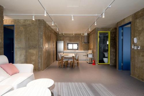 un salon avec un canapé blanc et une table dans l'établissement Gangneung Stayharam Villa, à Kyŏngp'o-mal