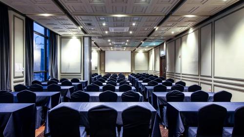 a conference room with blue tables and chairs at Golden Tulip Ever Yongin Hotel in Tugyeul