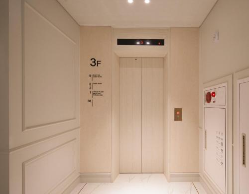 a hallway with a door with a sign on it at Jinhae Yongwon Londoner Business Hotel in Yongjae