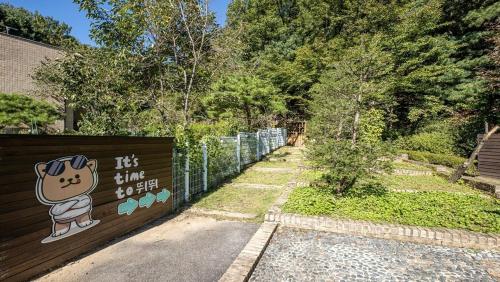 a fence with a sign with a dog on it at Glamdog Dog Pension Cheongpyeong Branch in Gapyeong