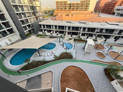 an overhead view of a building with a swimming pool at Cozy 1BR Near Abu Dhabi Airport in Abu Dhabi