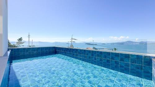 a swimming pool with a view of the water at Yeosu Road 328 Ocean View Pool Villa in P'yongsa-ri