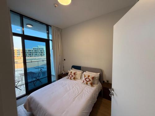 a bedroom with a bed and a large window at Cozy 1BR Near Abu Dhabi Airport in Abu Dhabi