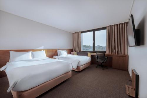 a hotel room with two beds and a desk at Jeonju Yeonghwa Hotel in Jeonju