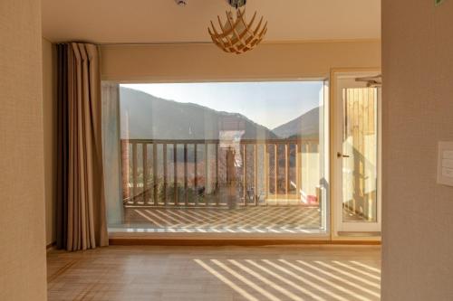 a room with a large window with a view of a balcony at Hwasun Byeolsan Pension in Wajun