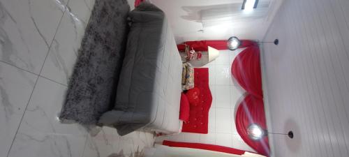 a bathroom with a bed and a red couch at Ksl refúgio dos pássaros in Araquari