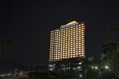 un edificio alto con luces encendidas por la noche en Hotel The PORA Suitz, en Sodong-ni