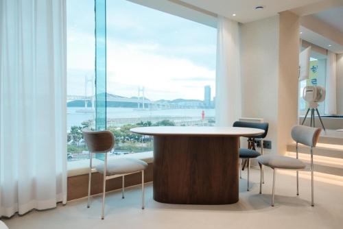 ein Raum mit Tisch und Stühlen und einem großen Fenster in der Unterkunft Cinnamon Stay Gwangan in Millak-tong