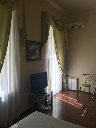 a bedroom with a bed and a television on a wooden floor at Kiev Centre Apartments in Kyiv
