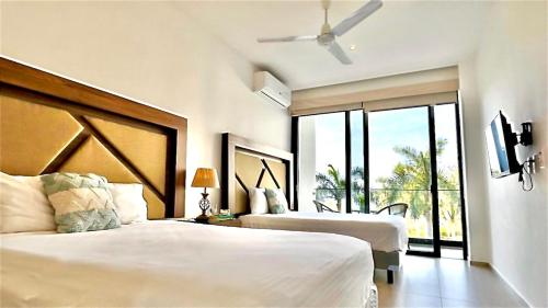 ヌエボ・バジャルタにあるBeach apartment 6px, Nuevo Vallarta Ocean Viewのベッドが2つと大きな窓がある寝室