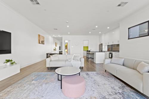a living room with a couch and a table at Swainson on 3 Lexington - 200m to Beach! in Henley Beach