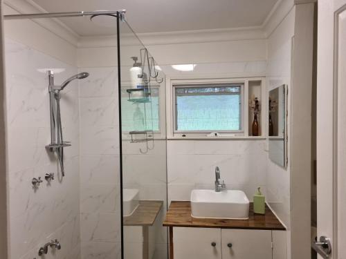 une salle de bain avec un lavabo et une douche en verre dans l'établissement Willows Cottage, à Warburton