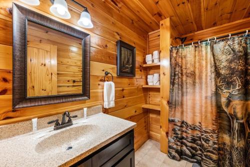 een badkamer in een blokhut met een douche en een wastafel bij Soggy Bears- Indoor Pool, Hot Tub, Views in Sevierville