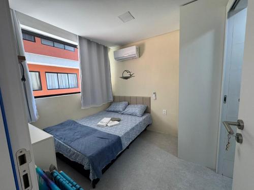 een kleine slaapkamer met een bed en een raam bij Mar de Campas - Tamandaré 016 in Tamandaré