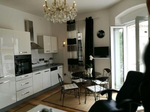 a kitchen with a table and chairs and a chandelier at Ana Apartment in Pula