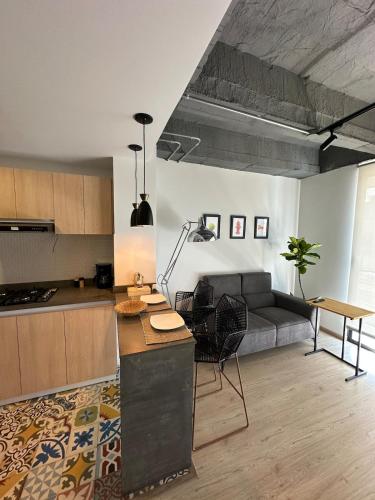 Una cocina y una sala de estar con un sofá. en Apartamento excelente ubicacion, en Sogamoso