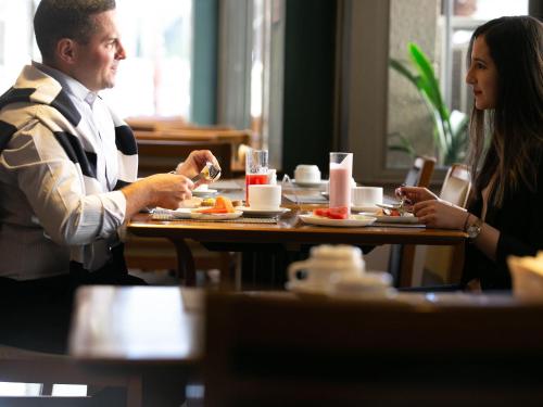 a man and woman sitting at a table in a restaurant at Mercure Sao Caetano do Sul in São Caetano do Sul