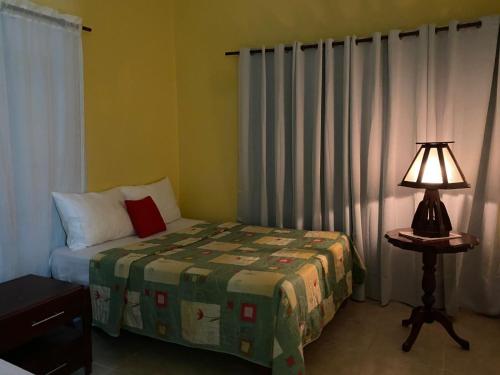 a bedroom with a bed and a lamp on a table at Aparta hotel vista al mar in Río San Juan