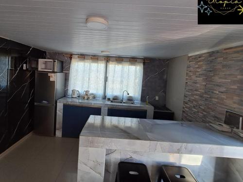 a kitchen with a sink and a refrigerator at Utopía in Balneario Argentino