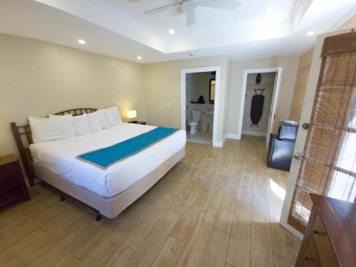 a bedroom with a large bed and a bathroom at Seashell Motel in Key West