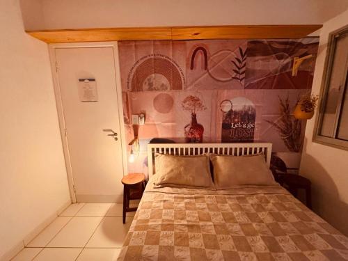 a bedroom with a bed and a wall at AP localização é tudo Pitangueiras in Guarujá