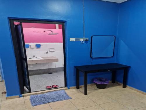 a blue bathroom with a black table and a mirror at Homestay Warisan Violet Bertam Jaya in Melaka
