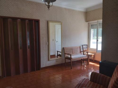 a living room with a chair and a mirror at Casa En Punta Mogotes in Mar del Plata