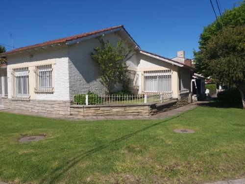 a white house with a fence in a yard at Casa En Punta Mogotes in Mar del Plata
