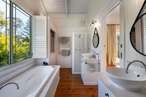 een badkamer met 2 wastafels, een bad en een groot raam bij Casa Adagio in Daylesford
