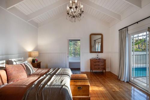 een slaapkamer met een bed, een spiegel en een kroonluchter bij Casa Adagio in Daylesford