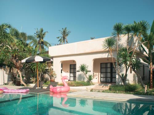a house with two pink flamingos in a swimming pool at El Campo Mushroom in Nusa Lembongan