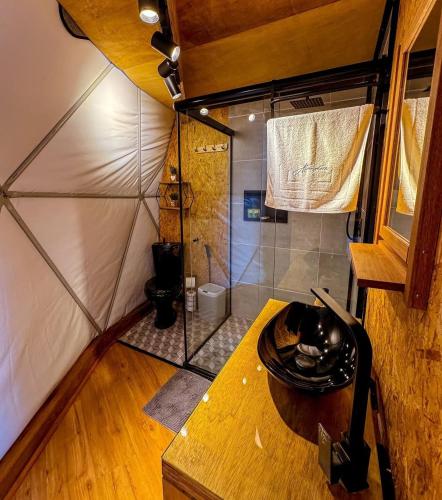 a small bathroom with a shower in a room at Glamping Atmosphera in Cambará