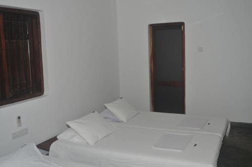 - 2 lits blancs dans une chambre avec fenêtre dans l'établissement Panthera Lodge, à Kirinda