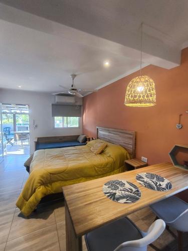 a bedroom with two beds and a table and a chandelier at Los Aromos in Federación