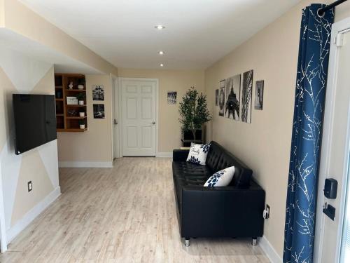 a living room with a black couch in a room at Cozy & private apartment outside the city center in Hampstead