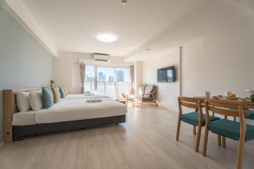 a bedroom with a bed and a dining room with a table at ESLEAD HOTEL Osaka Tsuruhashi in Osaka