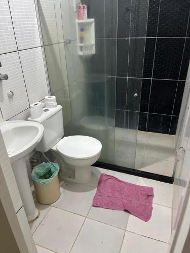 a bathroom with a toilet and a shower and a pink rug at Casa 6 in Olinda