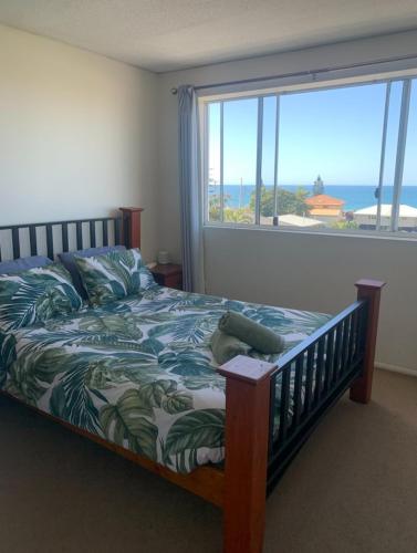 a bedroom with a bed with a view of the ocean at Platinum Apartments at Bargara in Bargara