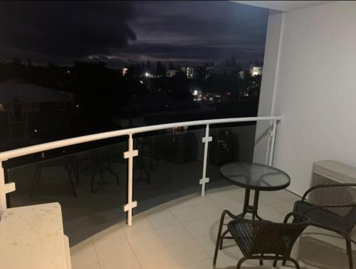 a balcony with chairs and a table and a view at Platinum Apartments at Bargara in Bargara