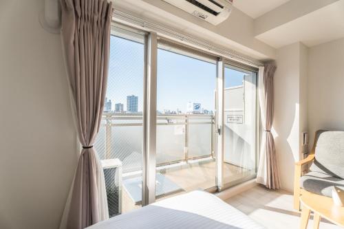 a bedroom with a bed and a large window at ESLEAD HOTEL Osaka Tsuruhashi in Osaka