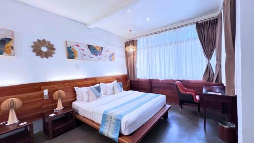a bedroom with a bed and a desk and a window at Critter Republic Dive Resort in Dauin