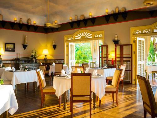 a dining room with white tables and chairs at La Veranda Resort Phu Quoc - MGallery in Phu Quoc