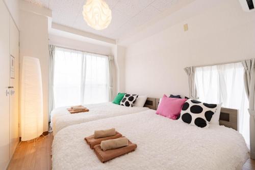 a bedroom with two beds with pillows on them at アンドステイ永福3丁目301 in Tokyo
