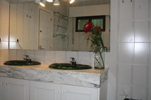 フエンヒロラにあるVilla Bonita Fuengirolaのバスルーム(洗面台2つ、鏡、花瓶付)