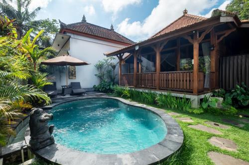 a swimming pool in the yard of a house at Anggi Villas Ubud in Tegalalang