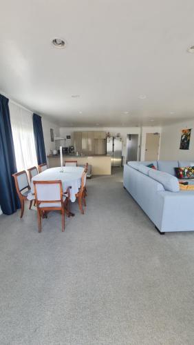un salon avec un canapé et une table dans l'établissement Scenic Coastal Gem with Pool, Tennis, Securely Gated, à Whangaparaoa