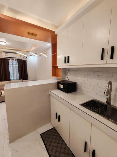 a kitchen with white cabinets and a sink at Townhouse in Malolos - Ezzy Good Spot in Malolos