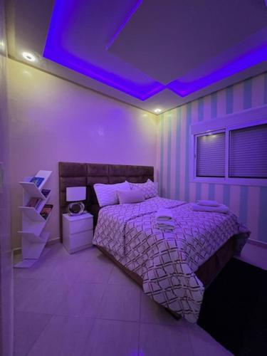 a bedroom with a bed with a purple ceiling at Résidences tazerzit smouna in Agadir